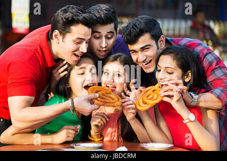 Les garçons, les filles du groupe des Amis manger agréable restaurant Fun Jalebi Banque D'Images