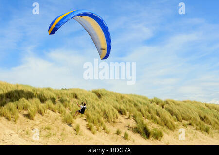 Ouddorp, Pays-Bas - juin 4, 2017 : Para planeurs volant au-dessus des dunes de la côte et d'avoir un grand temps. Banque D'Images