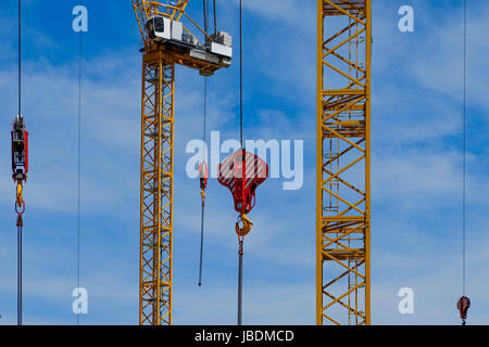 De nombreuses grues de construction jaune sur fond de ciel bleu Banque D'Images