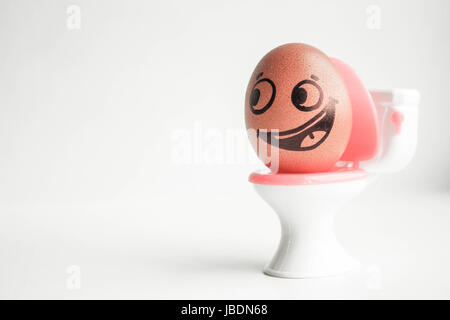 Pour enseigner à l'enfant de marcher sur le pot. Oeufs drôles avec visage peint concept. Sur blanc photo. électronique. La photo pour votre conception Banque D'Images