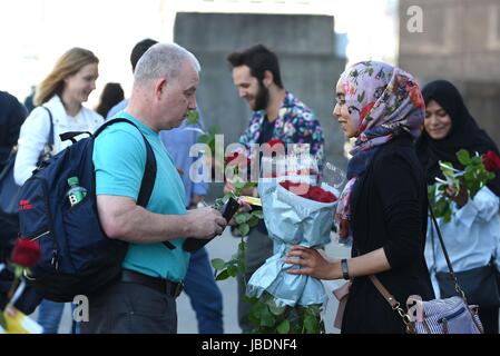 Des roses avec les messages sont distribués aux passants sur le pont de Londres plus d'une semaine après l'attaque terroriste sur le pont à Borough Market. Banque D'Images