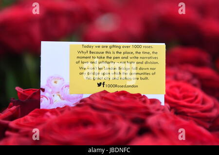 Des roses avec les messages sont distribués aux passants sur le pont de Londres plus d'une semaine après l'attaque terroriste sur le pont à Borough Market. Banque D'Images