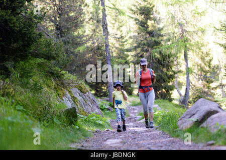 Mère et fils randonnées en forêt pour les lacs colbricon, Dolomites, Italie. Banque D'Images
