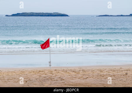 Drapeau rouge sur la plage de Portrush, l'Irlande du Nord indiquant un risque élevé tels que le surf ou de forts courants Banque D'Images