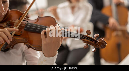 Orchestre symphonique de musique classique, l'exécution de l'article string femme violoniste jouant sur le premier plan, les mains close up Banque D'Images