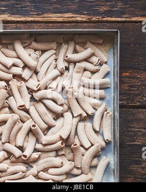 Les pâtes italiennes faites à la main dans de l'aluminium de cuisson sur la vieille table en bois Banque D'Images