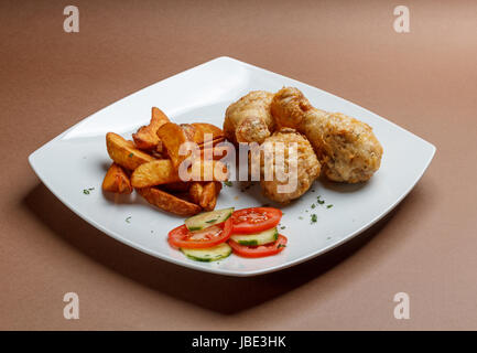 Pilons frit avec des frites sur fond brun Banque D'Images