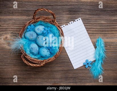 Panier en osier rempli d'oeufs de caille bleu avec feuilleton des avis Banque D'Images