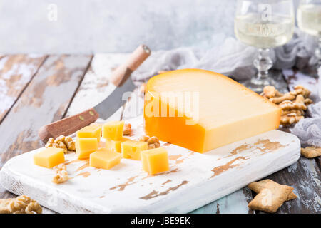 Délicieux fromage de gouda néerlandais avec blocs de fromage, craquelins, noix et couteau spécial sur la vieille table en bois. Copier l'espace. Banque D'Images