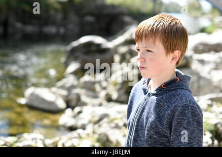 Jeune garçon, à la recherche sur l'eau de la rivière à Kirkby Lonsdale, Cumbria Banque D'Images