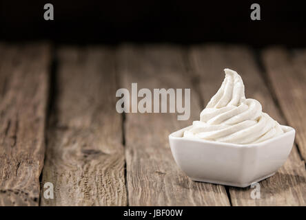 Jolie bol de crème glacée à la vanille crémeuse dans le coin sur une table en bois rustique avec beaucoup de copyspace pour votre texte Banque D'Images