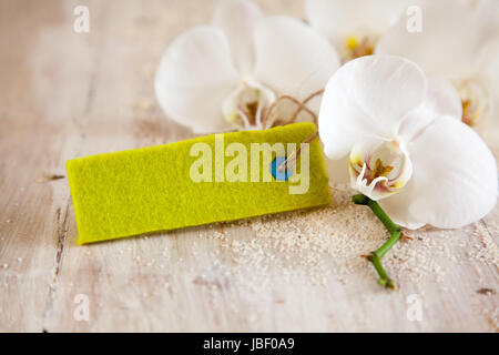 Deux belles fragile,fleurs orchidée Phalaenopsis blanche avec un blanc tag vert avec une texture de fibre sur les planches de bois rustique avec copyspace dans un concept de spa Banque D'Images