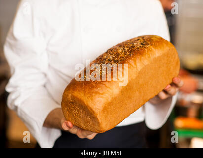 Male chef holding grain bread Banque D'Images