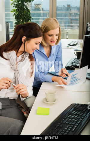 Les jeunes businesswomen discussing graphique à l'office de tourisme 24 Banque D'Images