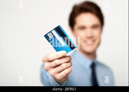 Young corporate guy montrant sa carte de débit Banque D'Images