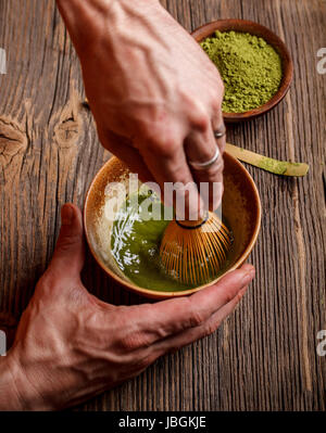 Battre le matcha en poudre et de l'eau avec un fouet en bambou Banque D'Images