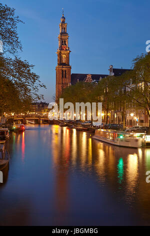 La photo est prise dans l'heure bleue et montre un canal et l'église Westerkerk (ouest) à Amsterdam. Les lumières de quelques lanternes sont refeflected dans l'eau. Banque D'Images