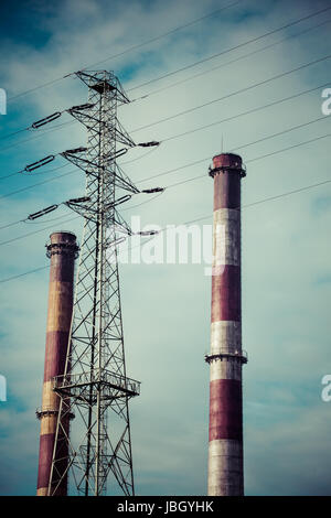 Ciel dramatique et deux cheminées industrielles et d'un pylône électrique à haute tension à partir de centrales électriques, à Gdansk, Pologne Banque D'Images