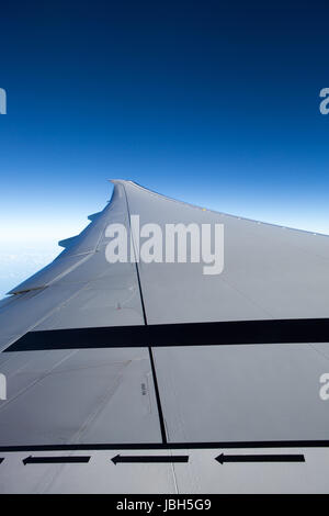 Voir l'aile d'avion à réaction de cristal avec ciel bleu en arrière-plan et la sûreté et la sécurité marqueurs comme des flèches de droite à gauche. Banque D'Images