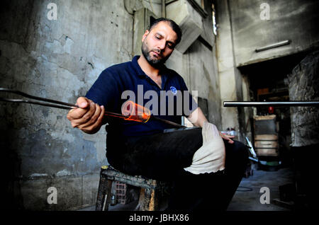 Damas, Syrie. 11 Juin, 2017. Un souffleur de verre en fusion de formes syrienne dans son atelier de Damas, capitale de la Syrie, le 11 juin 2017. En utilisant une technique d'abord développée par les phéniciens il y a environ 2000 ans, les souffleurs de verre forme le verre en fusion dans un four pour créer des cadeaux traditionnels populaires à Damas. Credit : Ammar Safarjalani/Xinhua/Alamy Live News Banque D'Images