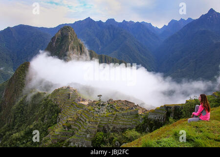 Femme profiter de la vue de la citadelle de Machu Picchu au Pérou. En 2007 Machu Picchu a été voté l'un des sept nouvelles merveilles du monde. Banque D'Images