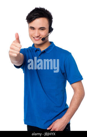 Smiling young man in headphones, thumb up Banque D'Images