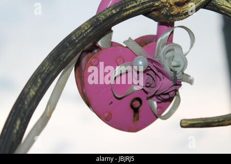 La serrure dans la forme de coeur accroché à un arbre artificiel métallique amoureux. Banque D'Images