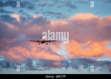 Voyageant par avion. L'atterrissage sur le coucher du soleil. Banque D'Images