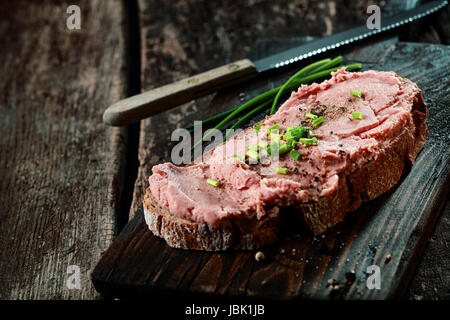 Teewurst allemand fumé salé sur une tranche de pain de seigle garni d'épices et la ciboulette fraîche hachée Banque D'Images