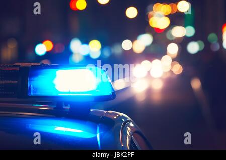 Danger sur la route. Clignotant bleu sur la voiture de police la nuit. Banque D'Images