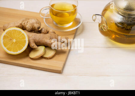 Tasse de thé au gingembre avec du citron et du miel sur fond de bois blanc. Banque D'Images