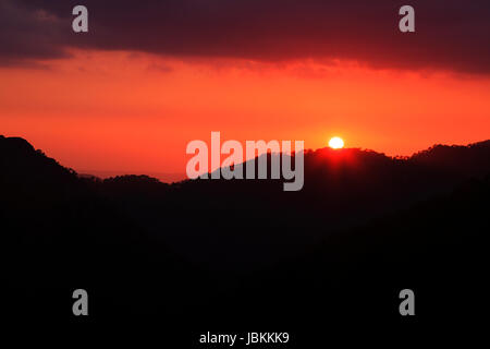 Le soleil derrière la silhouette de la forêt du mont Olympe dans la chaîne de montagnes Troodos, à Chypre. Banque D'Images