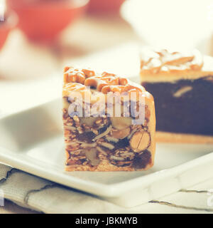 Mooncakes traditionnelles sur plaque blanche avec verre. Les mots en chinois sur l'mooncakes signifie fruits assortis les noix, pas un logo ou marque de commerce. Festival de mi-automne chinois aliments. Banque D'Images