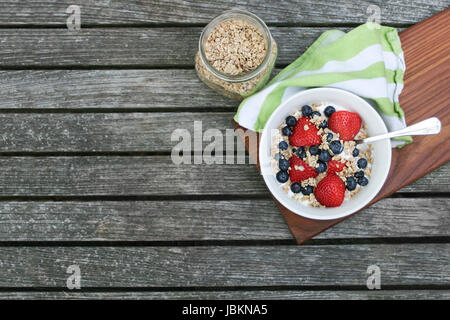 Petit-déjeuner sain bol. Dans un bol de granola blanc avec du yaourt grec et de baies sur fond de bois, vue ci-dessus, copiez l'espace, l'horizontale Banque D'Images