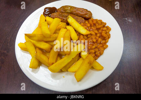 Un repas traditionnel café bon marché, saucisses, chips et des haricots à la sauce brune. Banque D'Images