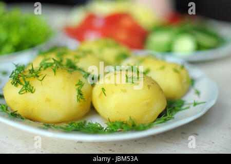 Les légumes frais biologiques et bouillie de pommes de terre nouvelles sur les plaques sur la table en bois. Close up, selective focus. Banque D'Images