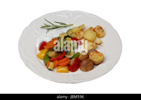 Plaque isolée avec légumes et pommes de terre au four Banque D'Images