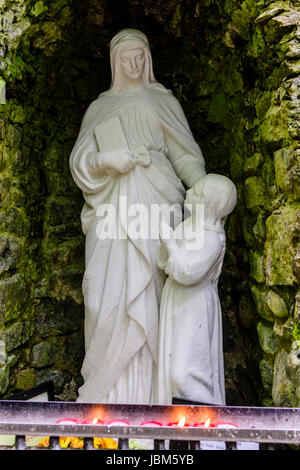 Grotte avec des statues de la Vierge et l'enfant Jésus, avec des chandelles allumées, à l'Tobarnalt puits sacré, Comté de Sligo, Irlande Banque D'Images