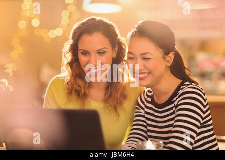 Smiling women friends using laptop Banque D'Images