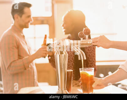 Couple drinking beer derrière bartender pouring beer bière au bar en Banque D'Images