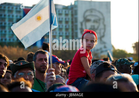 Jeune fille cubaine se déplace sur l'épaule de l'homme au défilé du jour de mai à La Havane, Cuba's Place révolutionnaire. Une figure de héros révolutionnaire Che Guevara. Banque D'Images