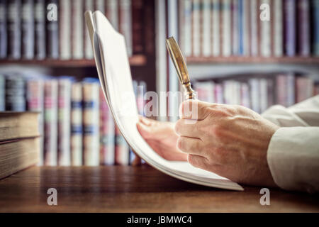 Businessman reading documents avec loupe concept pour l'analyse d'un contrat de financement ou contrat juridique Banque D'Images