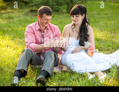 Portrait de couple marié juste l'évolution des anneaux sur meadow Banque D'Images