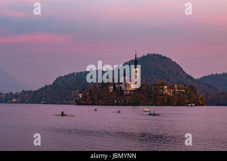 Les gens de l'aviron sur le lac de Bled au crépuscule Banque D'Images