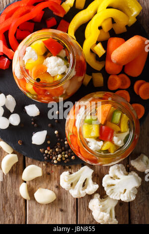 Salade de chou-fleur 672 mariné, poivre et les carottes close-up dans des bocaux en verre. vertical Vue de dessus Banque D'Images