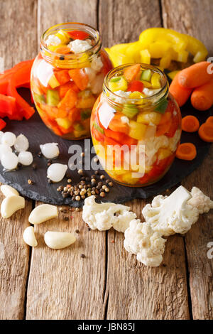 672 italien salade de chou-fleur au vinaigre, du poivre et les carottes close-up dans des bocaux en verre. La verticale Banque D'Images