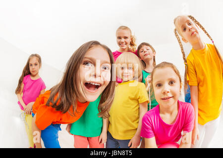 Fish Eye photo d'équipe de sport pour enfants, 5-6 ans, garçons et filles, s'amuser avec les jeunes entraîneur féminin, se tenant ensemble contre l'écran noir zone Banque D'Images