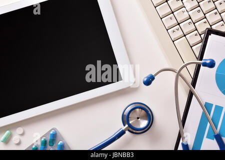 White Bureau Bureau d'un médecin avec tablette graphique, clavier de l'ordinateur, presse-papiers en rapport, stéthoscope et médicaments. Vue d'en haut. Composition horizontale. Banque D'Images