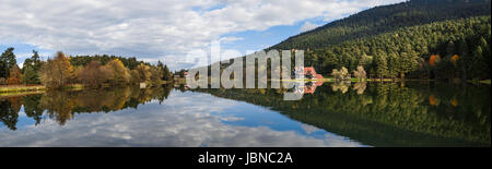 Vue panoramique sur le lac à l'intérieur de la maison en bois en forêt, parc national de Golcuk Bolu Turquie avec réflexion sur le lac sur ciel nuageux. Banque D'Images