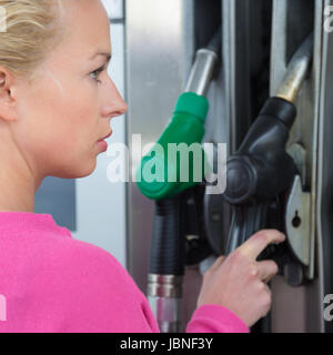 Pompage de carburant essence femme en voiture à la station d'essence. L'essence de l'essence ou pompée dans un véhicule à moteur voiture. Banque D'Images